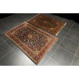 two Persian Keshan rugs in wool with typical design on a blue background || Lot van twee Perzische