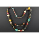 Himalayan necklace with beads in several materials and a "Dzi"-stone on a rope || Lot van een