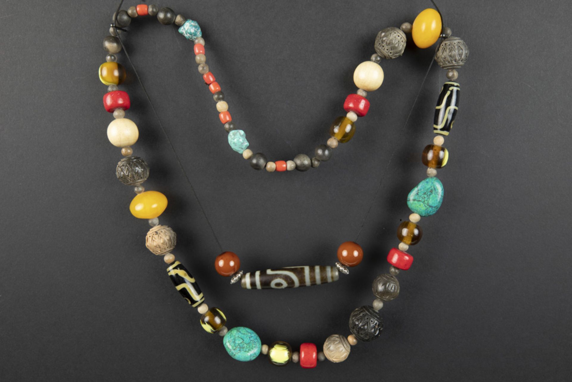 Himalayan necklace with beads in several materials and a "Dzi"-stone on a rope || Lot van een