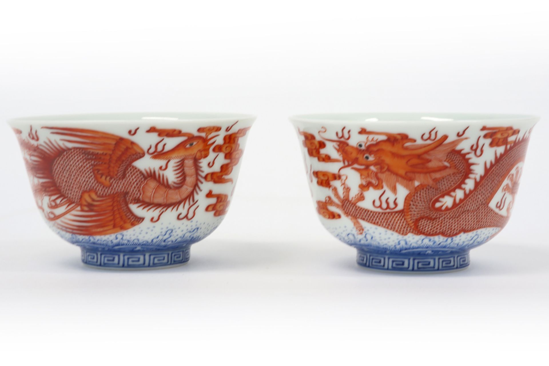 pair of Chinese cups in marked porcelain with blue-white and sanguine decors, one with a dragon