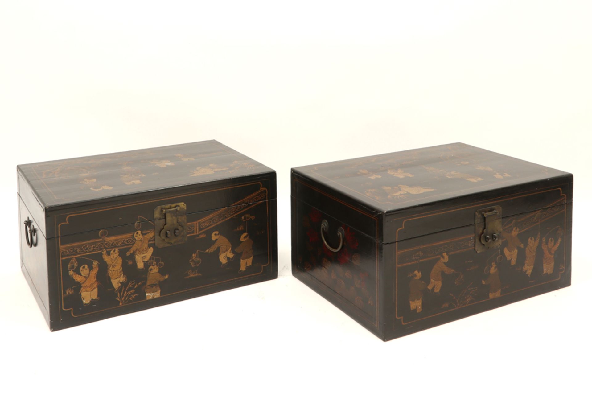 pair of antique Chinese chests in lacquered wood each with a top with a gilded decor with figures ||