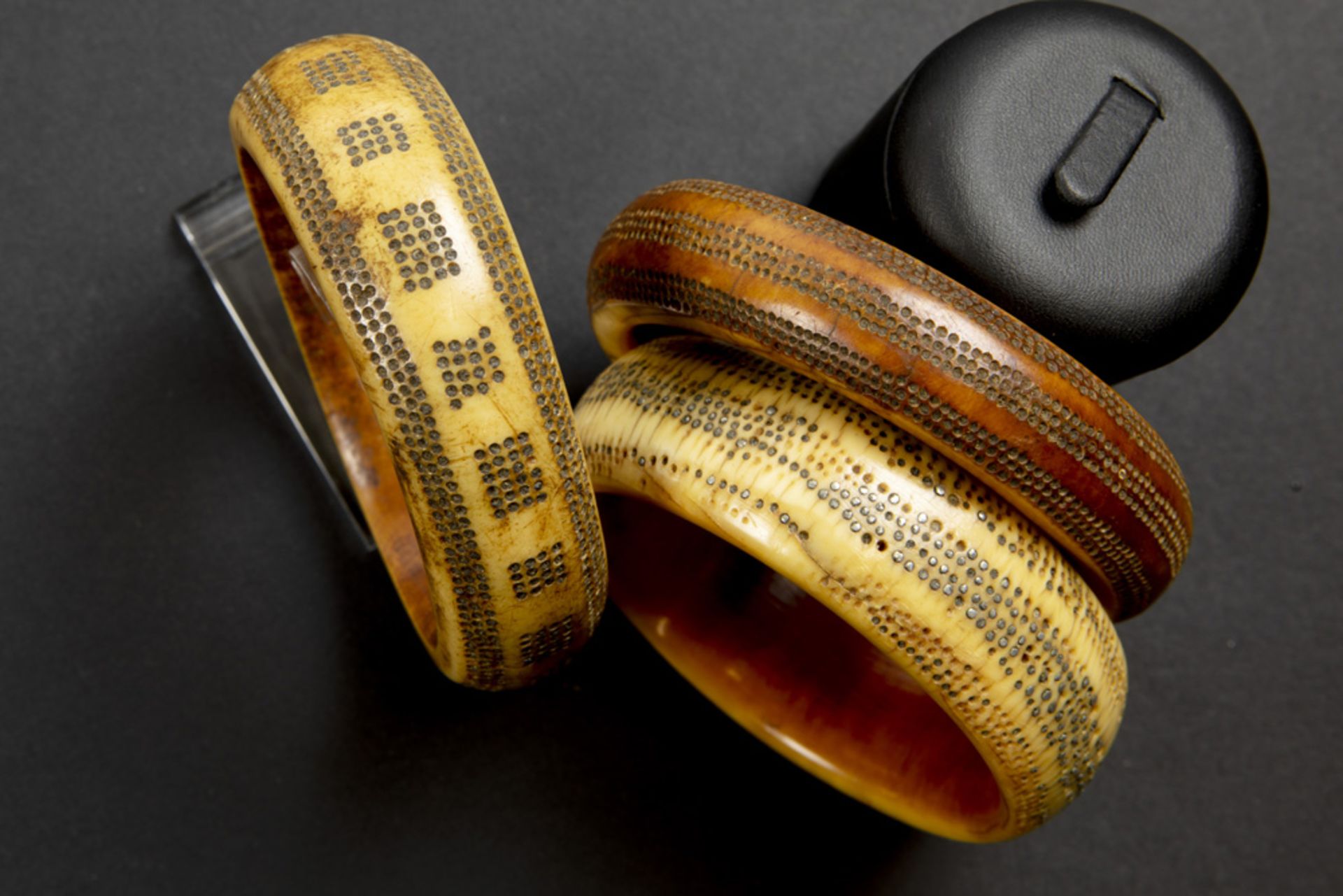 three African bone bangles with inlaid metal dots || Lot van drie Afrikaanse benen armbanden met