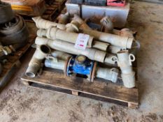 A quantity of irrigation piping couplings and a measuring dial on one pallet