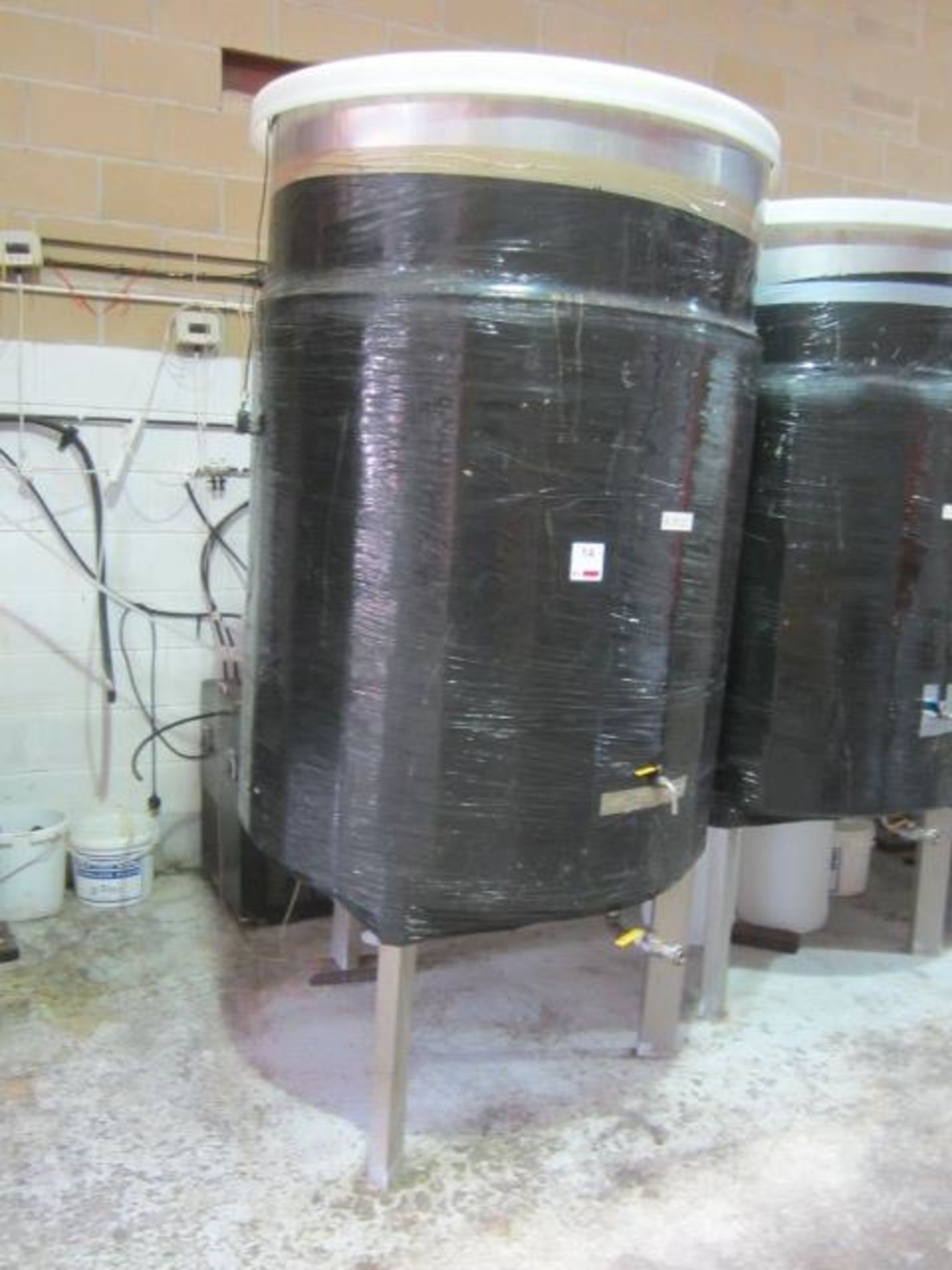 Stainless steel fermenting tank on three legged stand, with filling and drainage taps, 1200mm