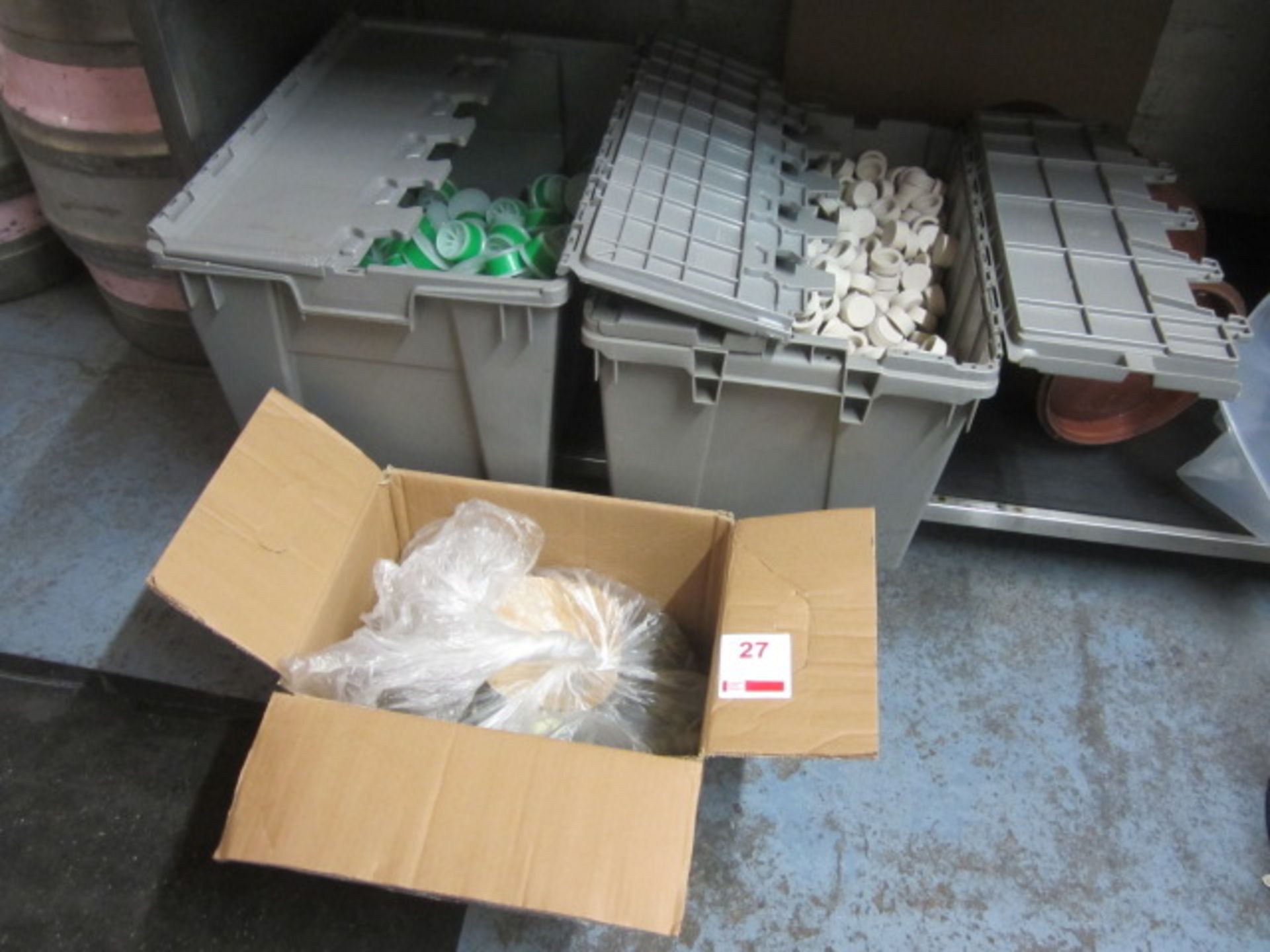 Two plastic crates of cask caps/seals and one bag of bottle caps