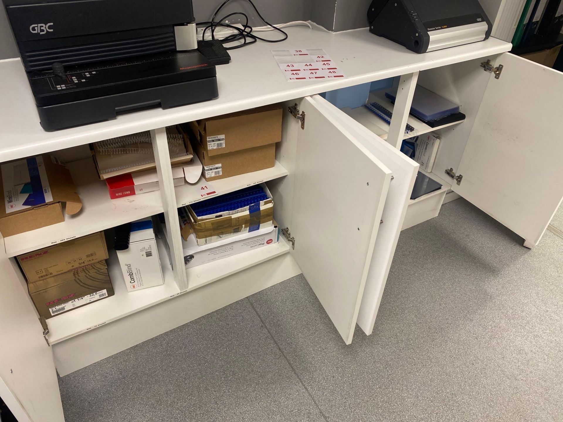 Contents of two cupboards to include various bookbinding accessories as lotted