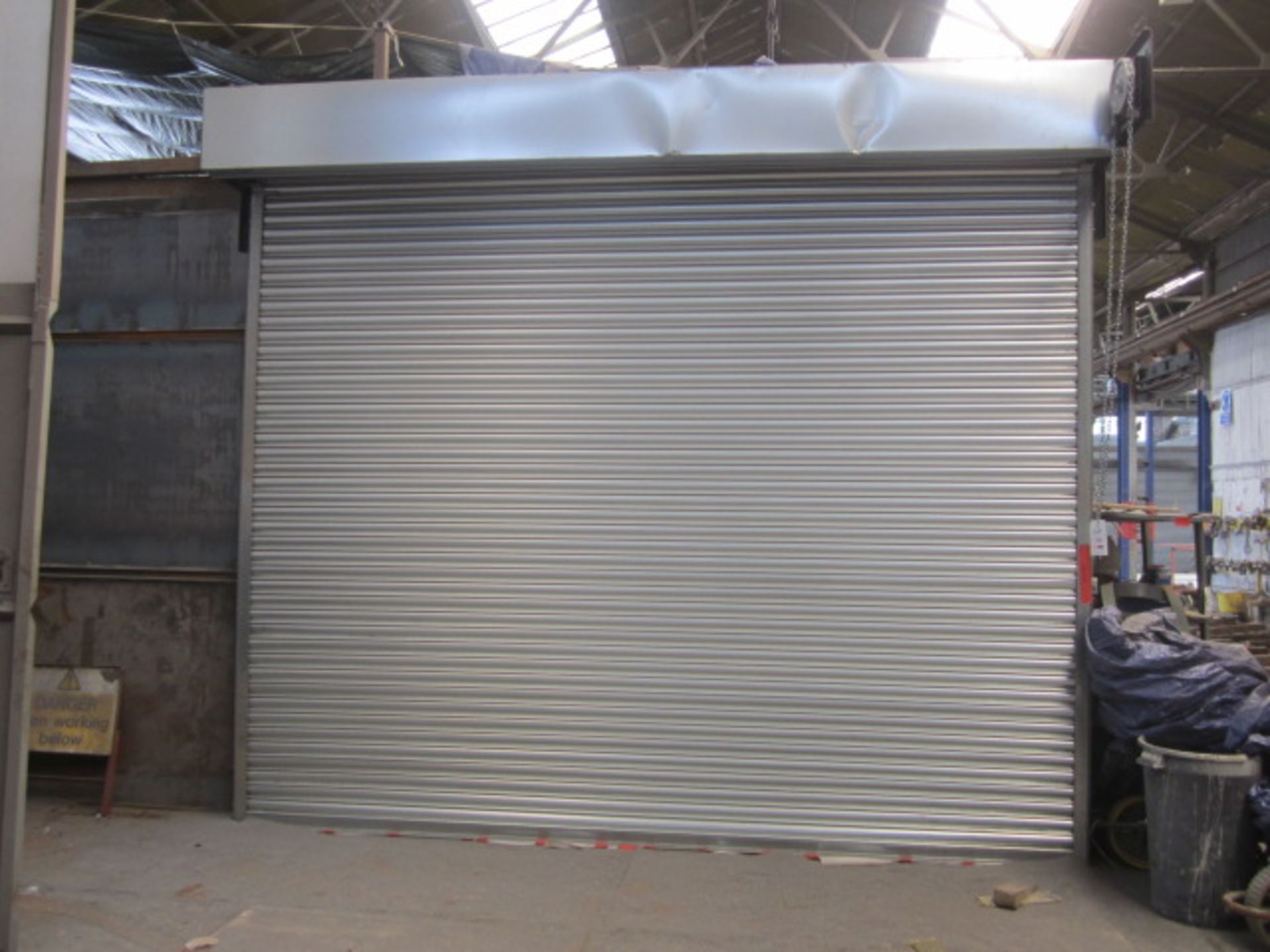 One steel framed wall mounted, manual operated roller shutter door (wheel & chain), door