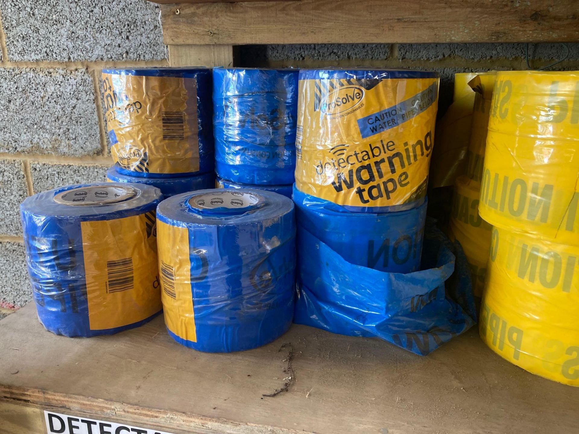 Contents of two shelves to include blue yellow and green detectable warning tape