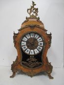 Ornate wood and brass mantle clock with Roman numerals