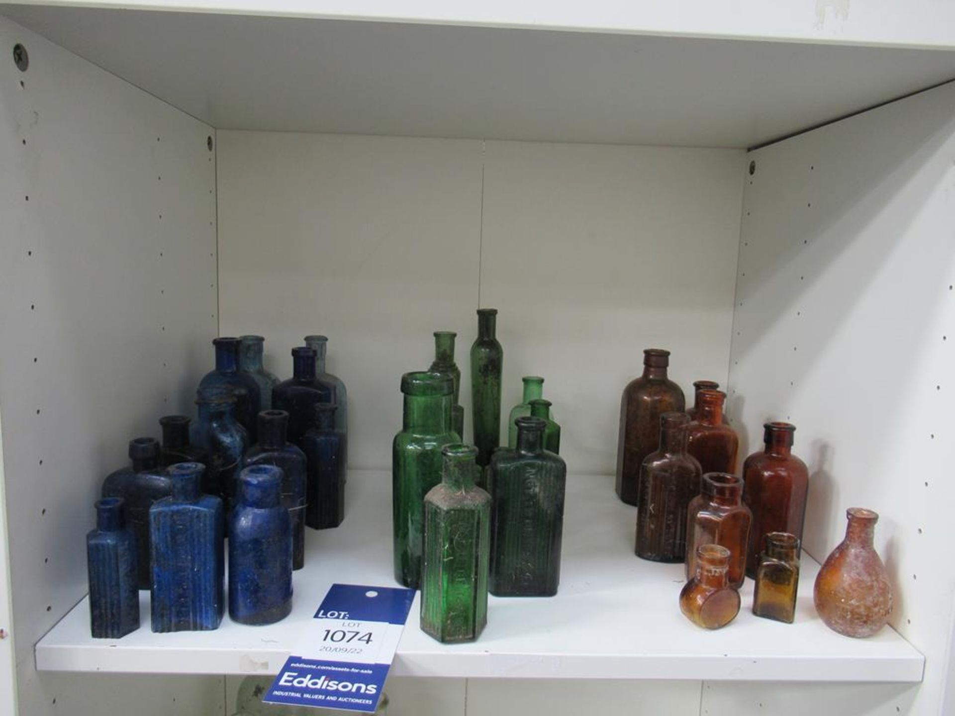 Shelf of Assorted Cobalt Green and Amber Bottles - many saying 'not to be taken'