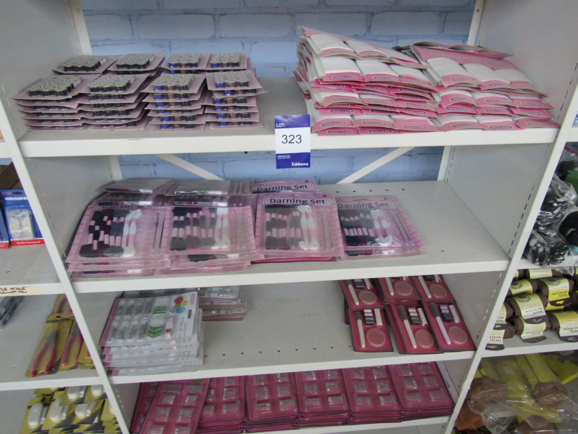 Contents of bay of shelving to include darning sets, sewing elastic, safety pins etc. – shelving not