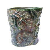 A Chinese spinach green jade brushpot of oval form, finely carved with a scene of a sage and