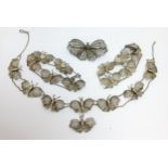 An early 20th century Indian white metal filigree butterfly jewellery set with conforming