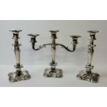 A silverplated candleabra and conforming candlesticks, decorated in relief with fruiting vines to