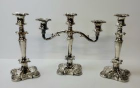 A silverplated candleabra and conforming candlesticks, decorated in relief with fruiting vines to