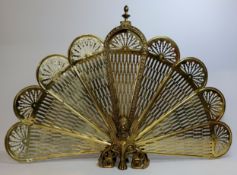 A substantial early 20th century brass 'peacock' firescreen, with mythical Griffin and lion paw