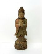 A Chinese deity, 18th century style, carved out of wood painted in polychrome, scrolling cloud base,