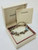 A genuine silver Pandora charm bracelet, holding thirteen charms including a car, horse, teacup, sun
