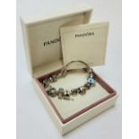 A genuine silver Pandora charm bracelet, holding thirteen charms including a car, horse, teacup, sun