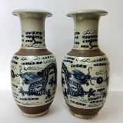A pair of large Chinese blue and white baluster vases decorated with dragons chasing the flaming