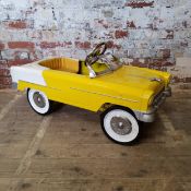 A child's pedal car modelled as a 1955 Chevy Bel Air, yellow & white body, silver trim, chrome