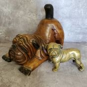 A large carved wood British bulldog, in a playful pose; a solid brass cast doorstop in the form of a