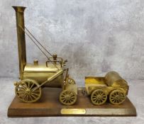 A brass model of Stephenson's Rocket mounted on a wooden plint