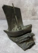 A bronze bookend in the form of a sailing vessel in trouble on a stormy sea, signed E.M.White with a