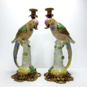 An impressive pair of large gilt metal mounted porcelain parrot candlesticks, each modelled as a