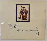 A 1950s autograph album page with the signatures in blue fountain pen of Stan Laurel and in blue