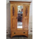 An Art Nouveau satin wood single wardrobe with oversized Art Nouveau copper escutcheons raised on