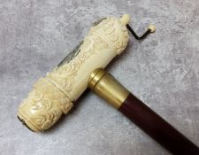 An unusual 'scrimshaw' walking stick carved with whaling ship, compass and fish, hardwood shaft, the