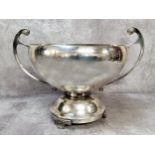 A silver two handled circular rose bowl, scroll handles, spreading circular foot, raised on three