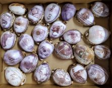 A collection of twenty five carved cowrie shell souvenirs