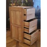 A contemporary light oak campaign style three drawer filing cabinet with brass drop handles of