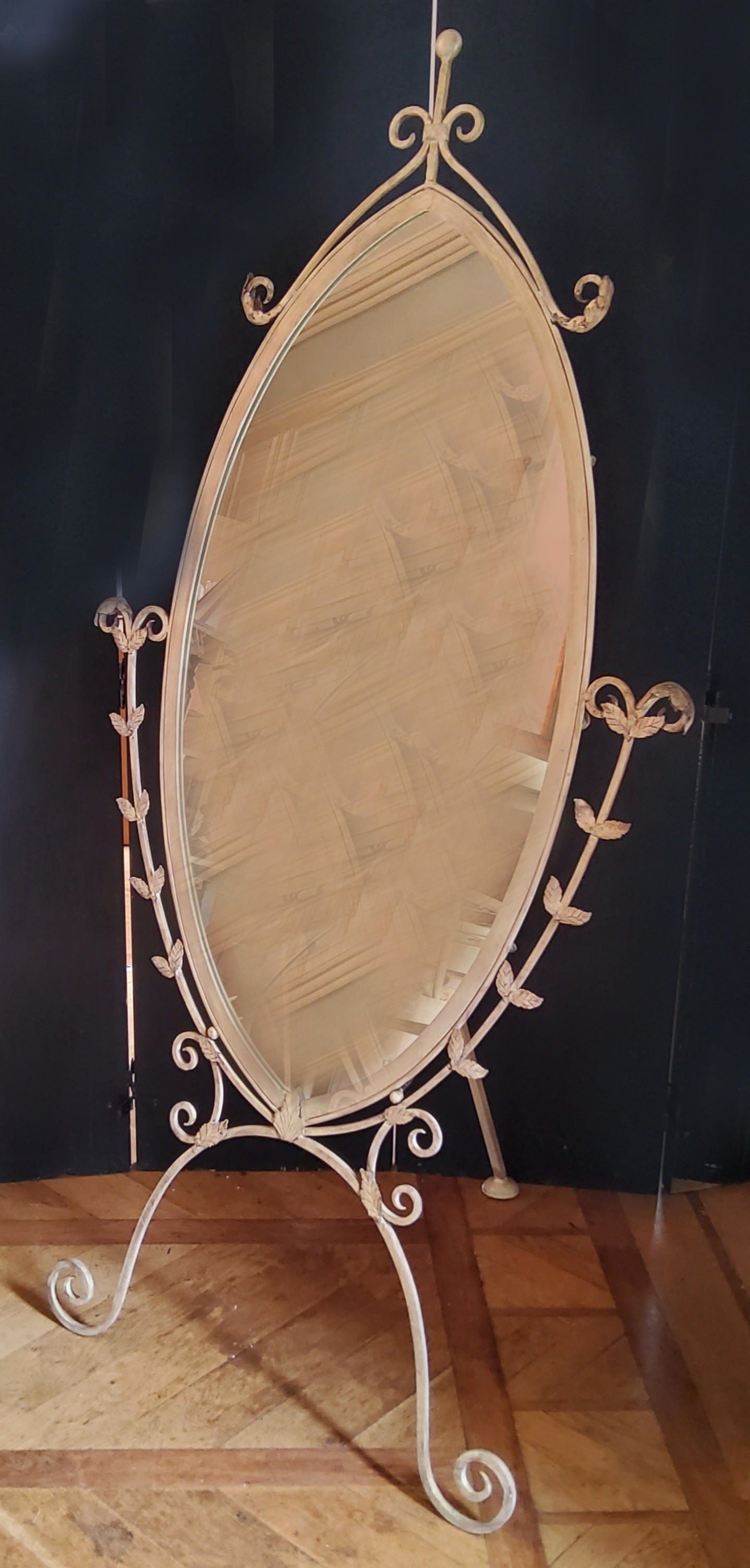 An oval shaped painted metal cheval mirror, distressed cream finish 185cms high