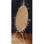 An oval shaped painted metal cheval mirror, distressed cream finish 185cms high