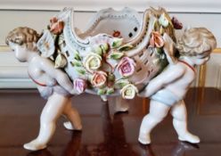 A Meissen centre piece the pierced bowl decorated with applied roses supported by three Putti base ,