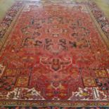 A very large hand knotted Persian Heriz design carpet in rich tones of deep red, white and black