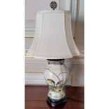 An Oriental hand painted ceramic baluster shaped lamp base decorated with parrots in a