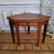 An unusual late Victorian mahogany canted corner table with single drawer to frieze raised on