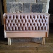 A deep button back single bed head with limed oak rope twist border details