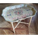 A contemporary decorative Papier-mâché style tray table, the tray decorated with red, green & yellow