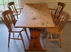 A farmhouse pine kitchen table with four chairs including two carvers, the table support with