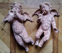 A pair of wall hanging plaster putti playing trumpets, terracotta effect (one missing trumpet)