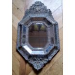 A large 19th century Continental repousse brass cushion frame mirror, planked back 93 x 55cm (af)