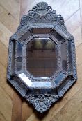 A large 19th century Continental repousse brass cushion frame mirror, planked back 93 x 55cm (af)