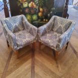A pair of Regency style hotel reception tub chairs upholstered in tones of blue floral pattern,