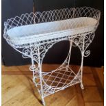 A Victorian style wrought metal elongated oval jardiniere stand, the white painted metal wirework