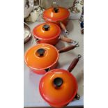 Le Creuset a set of four graduated cast iron, orange enamel saucepans & covers